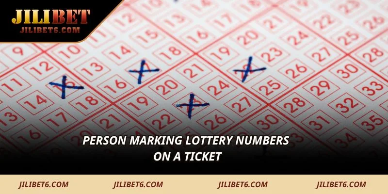Person marking lottery numbers on a ticket